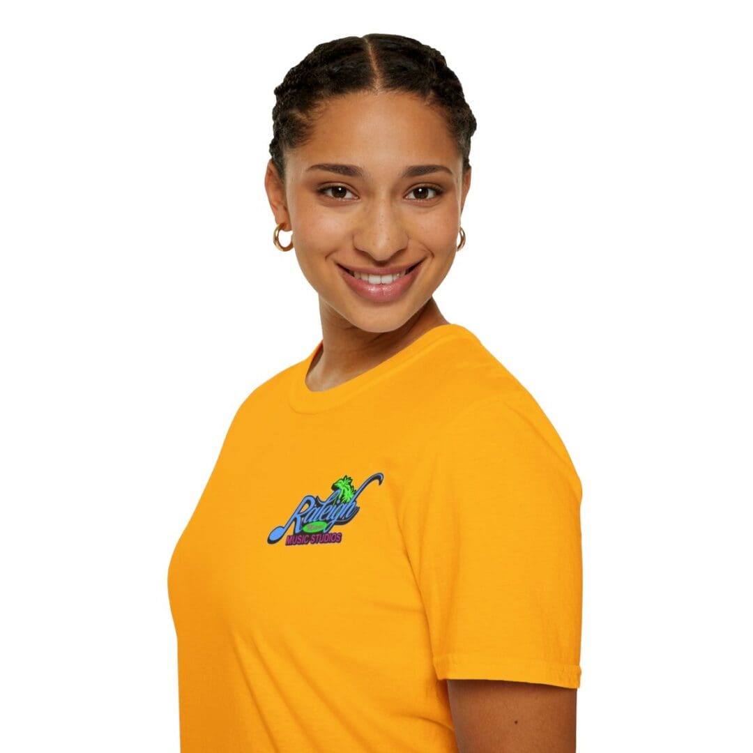 Woman smiling, wearing gold Raleigh Music Studios tee.